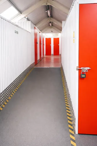 Storage corridor with red unit doors and padlocks